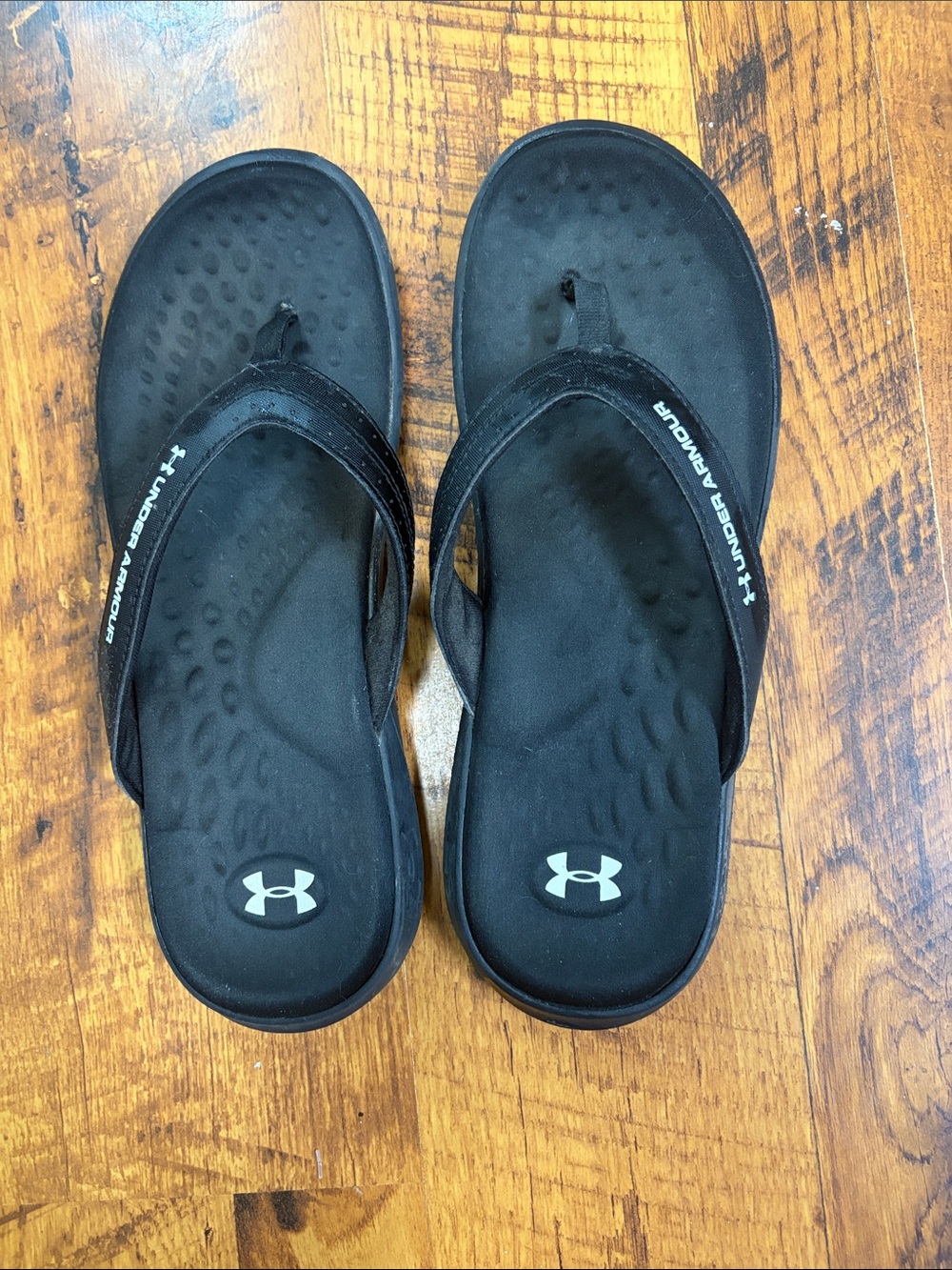 Women’s black under Armour flip-flops